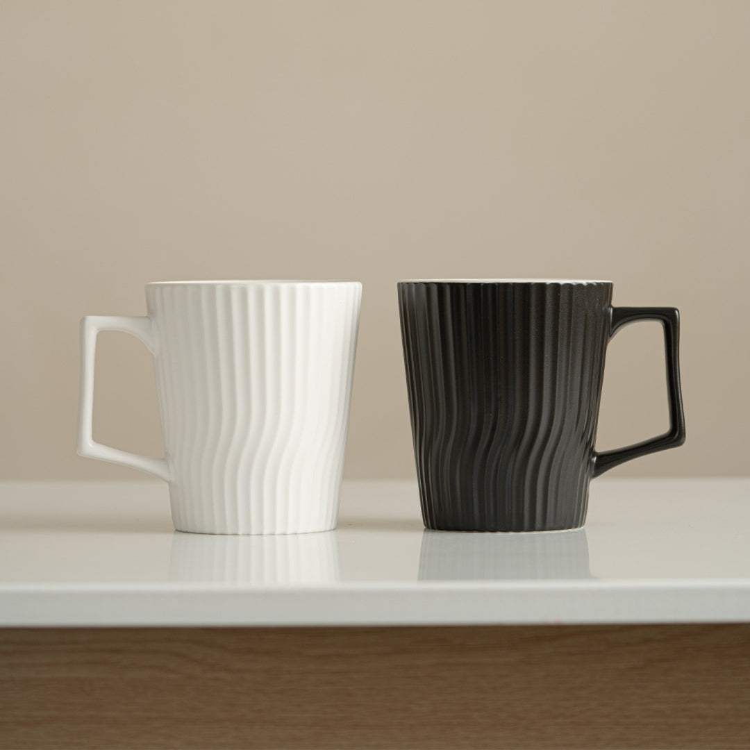 Ceravor white ribbed ceramic coffee mug with coffee next to laptop