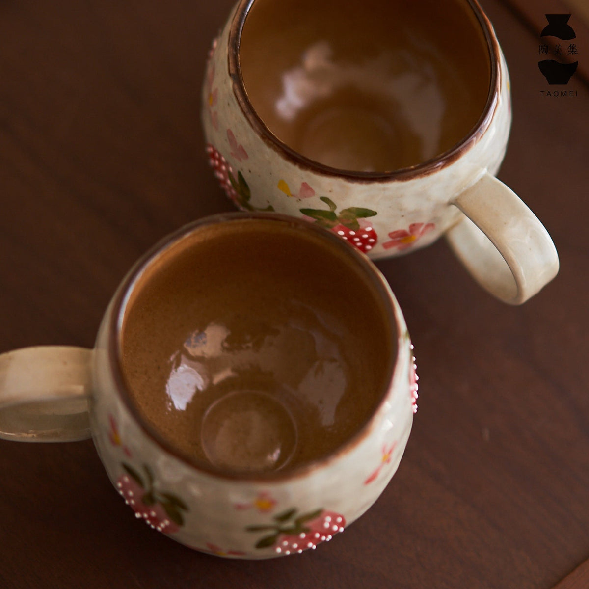 Two Ceravor strawberry ceramic mugs showing the smooth brown interior