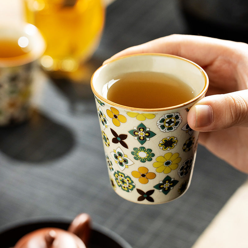 Hand holding Ceravor retro floral ceramic teacup filled with tea