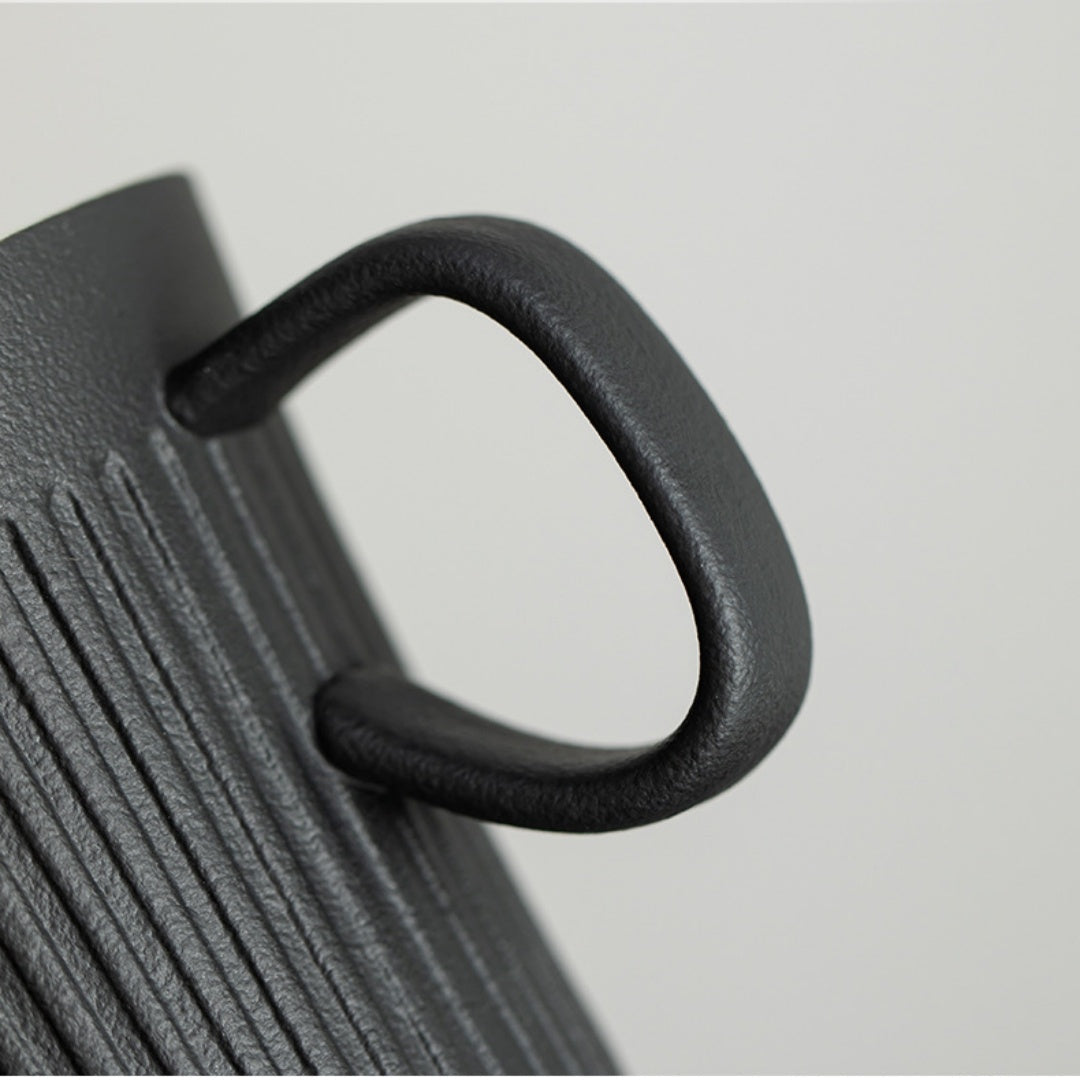 Ceravor black ribbed ceramic coffee mug with coffee being stirred