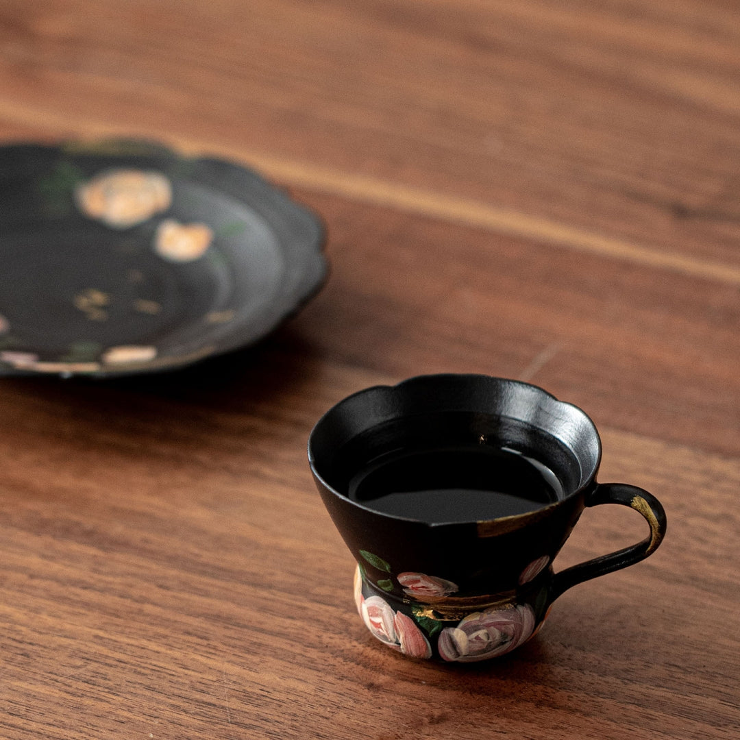 Hand holding Ceravor black floral espresso cup