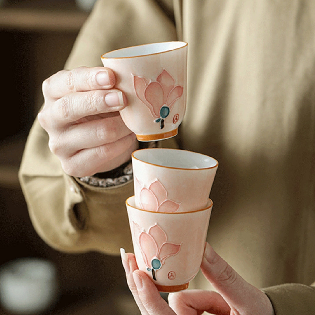 Person stacking three Ceravor floral ceramic aroma teacups