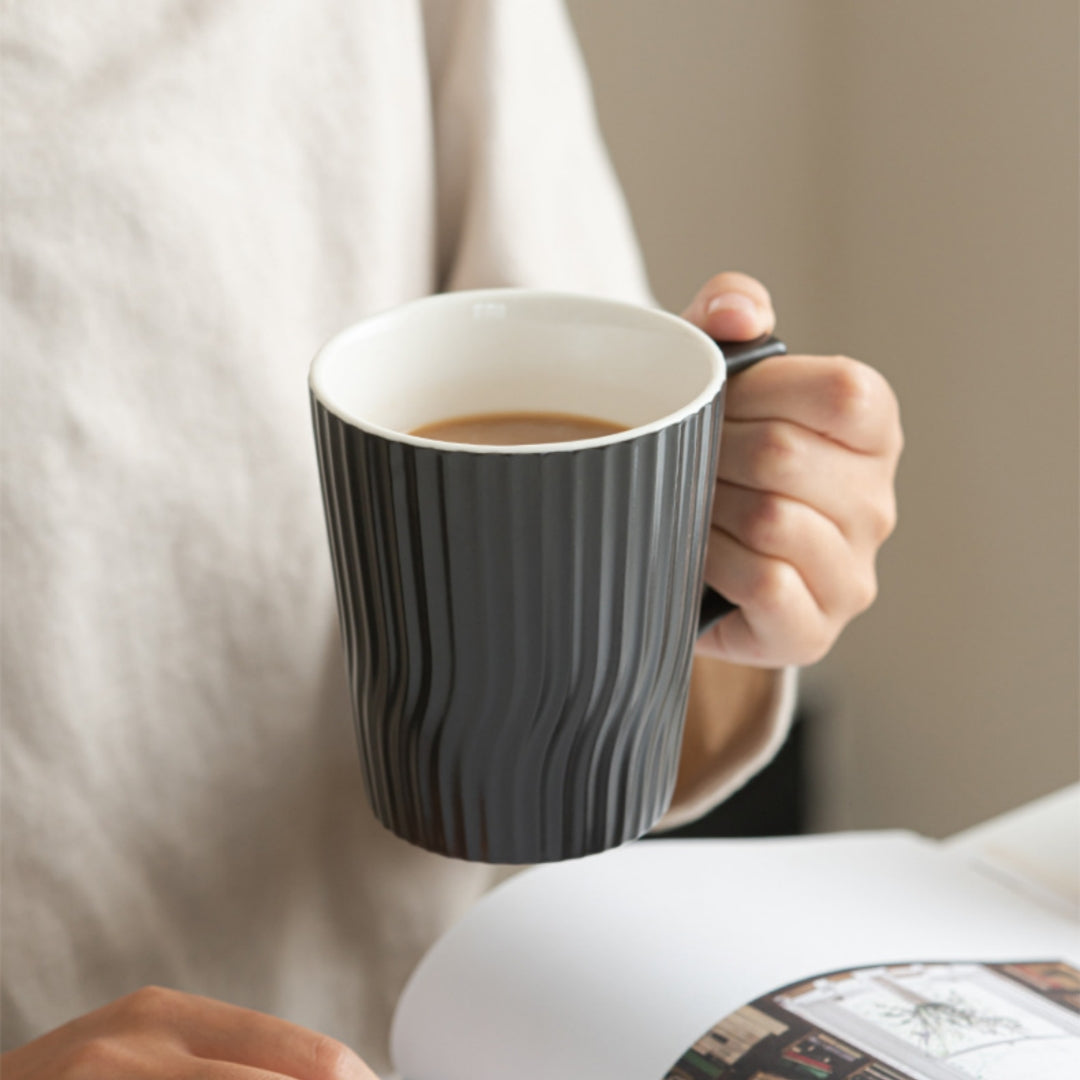 Pouring water into Ceravor black ribbed ceramic coffee mug on wooden tray