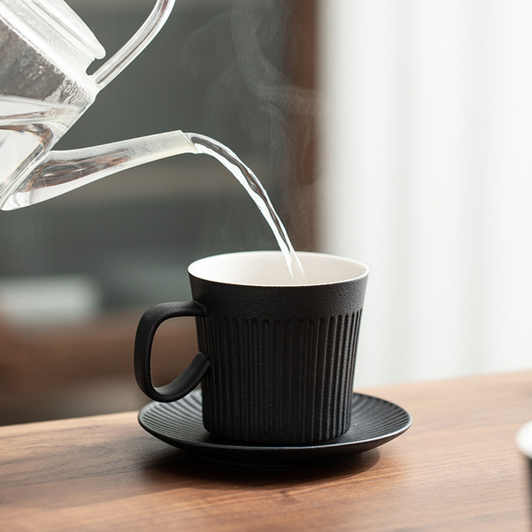 Ceravor black ribbed ceramic mug being used to pour coffee