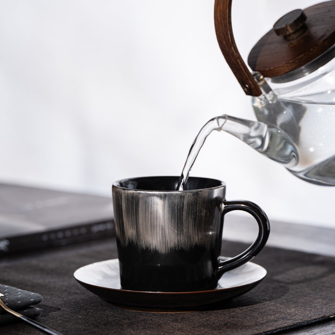 Hand holding Ceravor Linglong window tracery cup with dark coffee