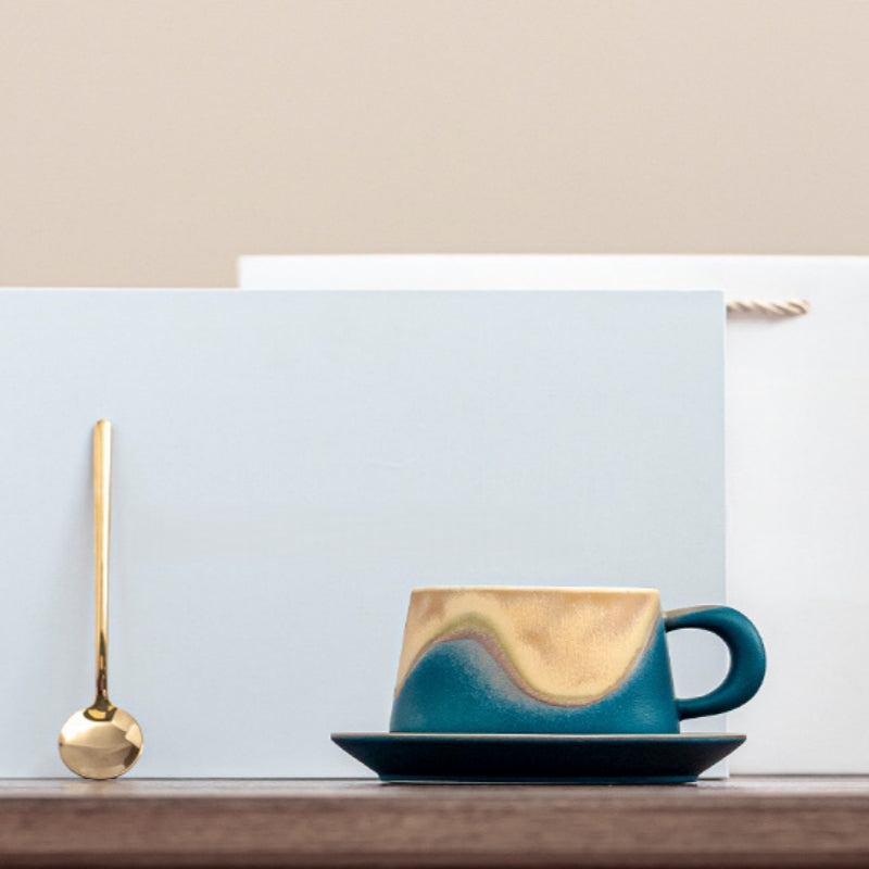 Hand holding Ceravor ocean blue ceramic cup with latte