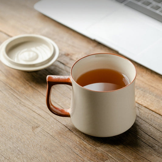 Ceravor ceramic mug with lid and tea next to a laptop on a wooden desk
