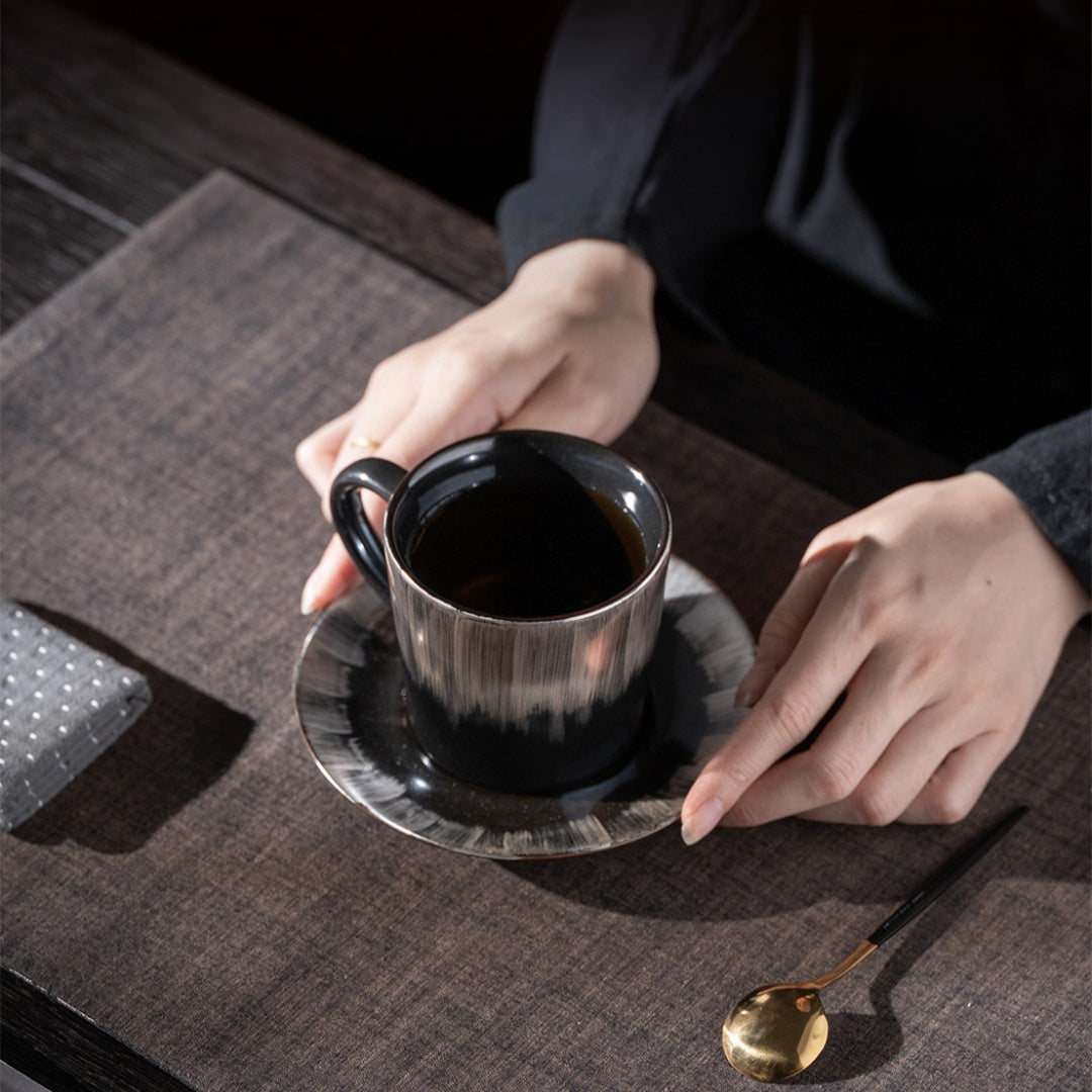 Person holding Ceravor Linglong white ceramic cup against dark background