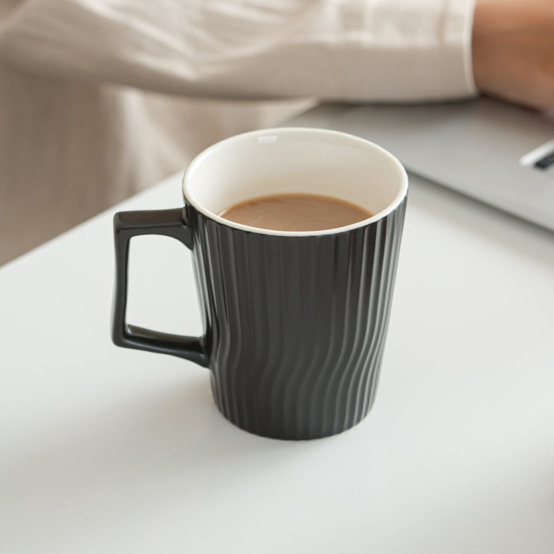 Person holding Ceravor black ribbed ceramic coffee mug